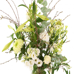 Geplukt kerstboeket witte bloemen in glazen melkbus vaas